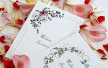 A collection of hand-tinted floral wedding stationery featuring original hand-drawn artwork.