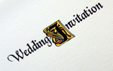 A collection of hand-crafted wedding stationery decorated with illuminated letters.